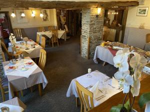 a dining room with white tables and white flowers at Auberge de L'an 1600 in Bouillon