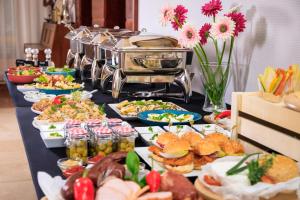 a long table with a buffet of food on it at Hotel Bartan Gdansk Seaside in Gdańsk