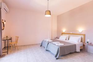 a bedroom with a bed and a table and a chair at Garden Budget Rooms By Dominoes Corfu in Ipsos +62 photos