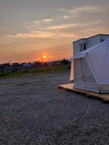 a tent sitting in a parking lot at sunset at TrainLineField in Tōbetsu