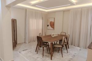 a dining room with a wooden table and chairs at جيوار in 6th Of October