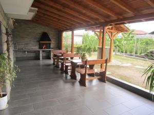 a patio with wooden benches and a fireplace at Slavina Guest House in Sapareva Banya