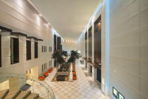 a hallway of a building with a lobby with palm trees at Hyatt Regency Dubai - Corniche in Dubai