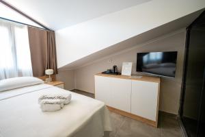 ein Schlafzimmer mit Bett und Flachbildfernseher in der Unterkunft Dalyan Lorend Inn in Dalyan