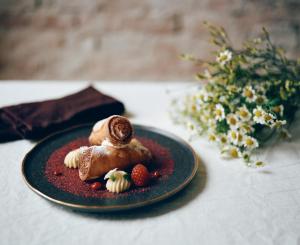 a black plate with a dessert on a table at Aria Hotel Budapest by Library Hotel Collection in Budapest