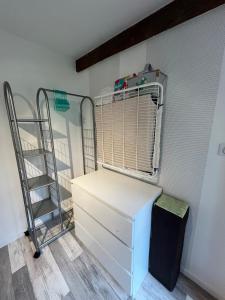 a room with a white dresser and a shelf at La petite maison in Souday