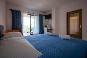 duże niebieskie łóżko w pokoju z oknem w obiekcie Apartments Gaja blue ap w mieście Sveti Filip i Jakov