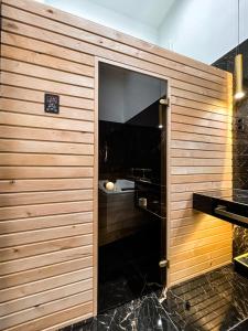 ein Badezimmer mit einer Holzwand und einem großen Fenster in der Unterkunft St Stephen Luxury Spa Residence in Budapest