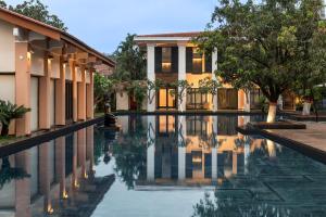阿利鲍格Taj Alibaug Resort & Spa, Maharashtra的建筑物前的游泳池