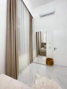 ein weißes Schlafzimmer mit einem Bett und einem Spiegel in der Unterkunft St Stephen Luxury Spa Residence in Budapest