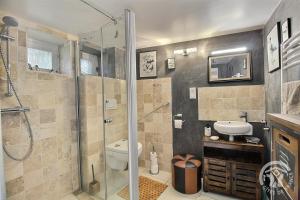 a bathroom with a shower and a toilet and a sink at La petite maison de dom in Pleslin-Trigavou +22 photos