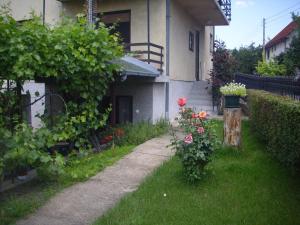 a house with a garden with flowers in the yard at Guest House Nada in Soko Banja