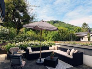 a patio with a couch and an umbrella at Miltenberg Moments Ferienwohnung in Miltenberg