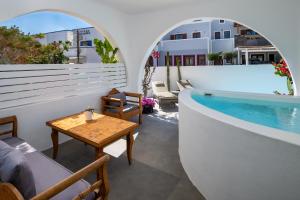 a room with a pool and a table on a balcony at Nissia Beach Apartments & Suites in Kamari