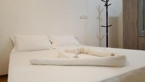 un letto bianco con un asciugamano sopra di Maafushi View a Maafushi