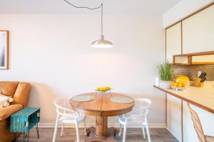 eine Küche mit einem Holztisch und weißen Stühlen in der Unterkunft Waterfront condo one block to Oceanfront in Sea Breeze