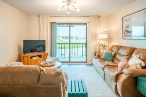 ein Wohnzimmer mit Sofa und Fernseher in der Unterkunft Waterfront condo one block to Oceanfront in Sea Breeze