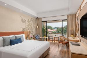 阿利鲍格Taj Alibaug Resort & Spa, Maharashtra的一间带一张白色大床的卧室和一间客厅