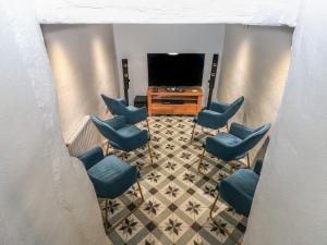 a waiting room with blue chairs and a television at Blacksmiths Cottage in Pembroke