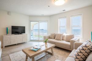 a living room with a couch and a tv at Villa Capriani 218B Oceanfront with Pool at North Topsail Beach in Chadwick Acres