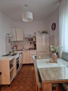 a kitchen with white appliances and a table in it at APARTMAN SMOLJIC 4+2 in Primošten