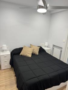 un letto con piumone nero in una camera da letto di Oasis a Bilbao