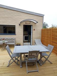 a picnic table and four chairs on a patio at Le petit Préau 10 min plages in Coudeville