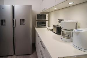 a kitchen with a refrigerator and a microwave at Hostel Sol in Dubrovnik
