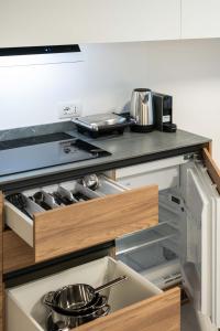 a kitchen with an open drawer with pots and pans at Monolocale Margherita - Cascina Da Rosa in Capiago Intimiano +13 photos