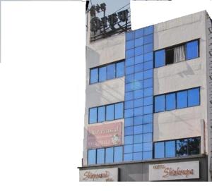 a tall building with a sign on the side of it at Hotel Shivkrupa in Pune