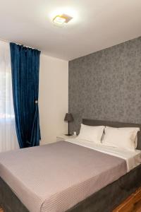 a bedroom with a large bed with a blue curtain at Sani Beverly Hills Luxury Villas in Sani Beach +57 photos