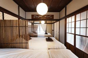 two beds in a room with two windows at Traditional Japanese House in Wada