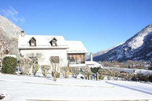 a house in the snow with mountains in the background at La maison Bellevue in Antignac
