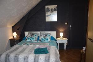 a bedroom with a bed with blue towels on it at La maison Bellevue in Antignac
