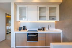 a kitchen with white cabinets and a sink at Casa Tierra - Villa II in Kos Town