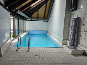 a swimming pool in a room with a tiled floor at Paradies 1 in Bonn