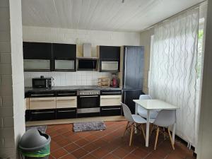 a kitchen with black and white appliances and a table at Paradies 1 in Bonn