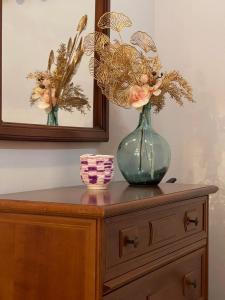 a vase with flowers on top of a dresser at Apartamento El Llerau Cangas de Onis in Cangas de Onís