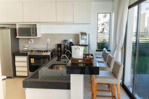 a kitchen with white cabinets and a black counter top at The Coral Beach Resort in Trairi
