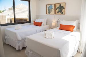 two beds in a room with a window at The Coral Beach Resort in Trairi