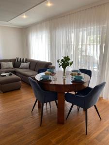 a living room with a wooden table and blue chairs at Private pool 2 rooms in Biograd na Moru