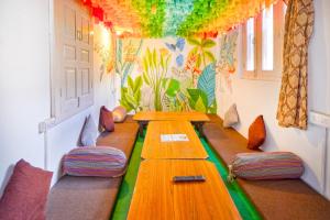a room with two long wooden tables and chairs at Jungle by sturmfrei Manali in Manāli