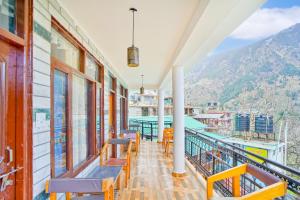 a balcony with benches and a view of the mountains at Jungle by sturmfrei Manali in Manāli