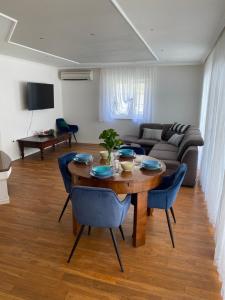 a living room with a wooden table and blue chairs at Private pool 2 rooms in Biograd na Moru