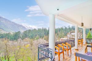 a balcony with orange chairs and a view of the mountains at Jungle by sturmfrei Manali in Manāli