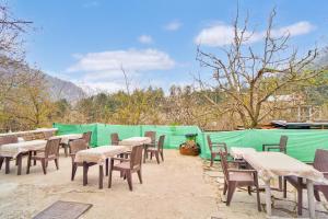 a group of tables and chairs with mountains in the background at Jungle by sturmfrei Manali in Manāli