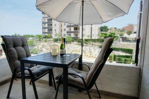 a table with two chairs and an umbrella on a balcony at Torrevieja - Lux appartement in San Miguel de Salinas
