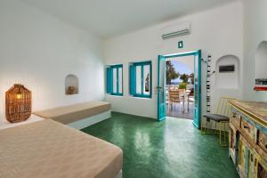 a room with two beds and a room with a table at Nissia Beach Apartments & Suites in Kamari