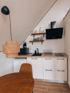 une cuisine avec des armoires blanches et une table dans l'établissement Luna by NorAtlas Heritage, à Varlaam