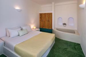 a bedroom with a bed and a bath tub at Nissia Beach Apartments & Suites in Kamari